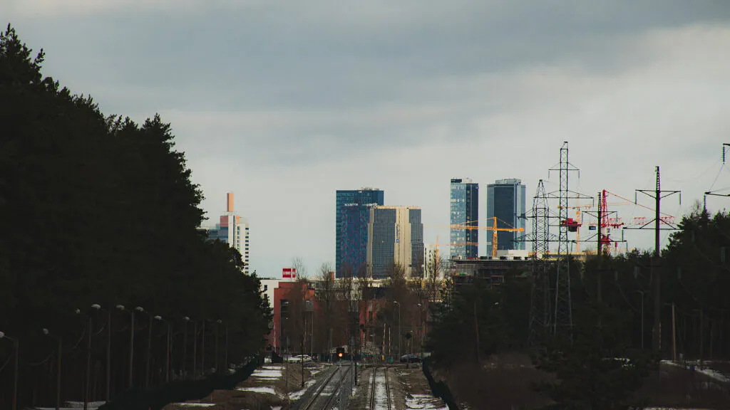 Railway tracks, power lines and Tallinn skyline beside Järve forest