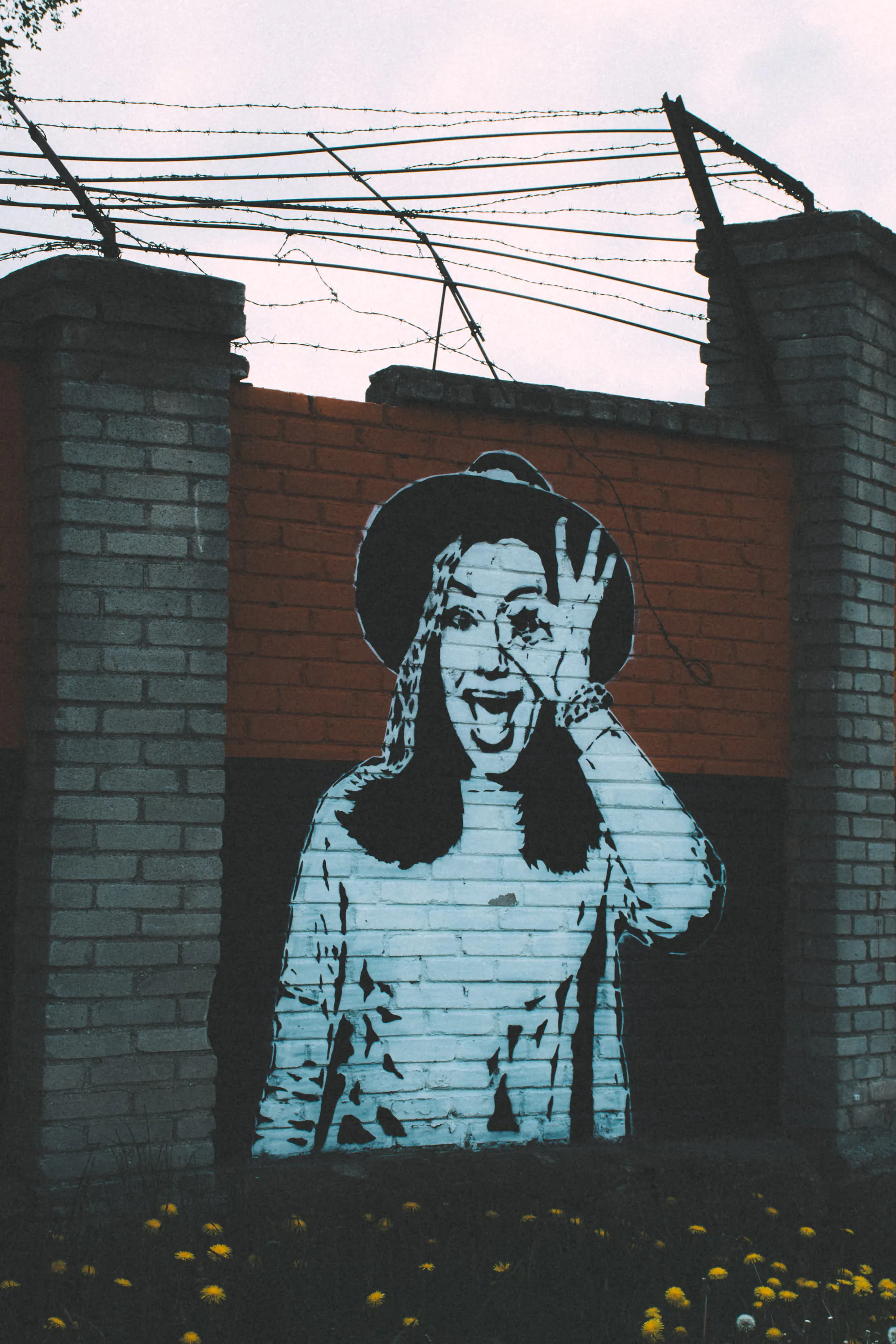 Black-and-white street art painted on a brick wall in Kopli