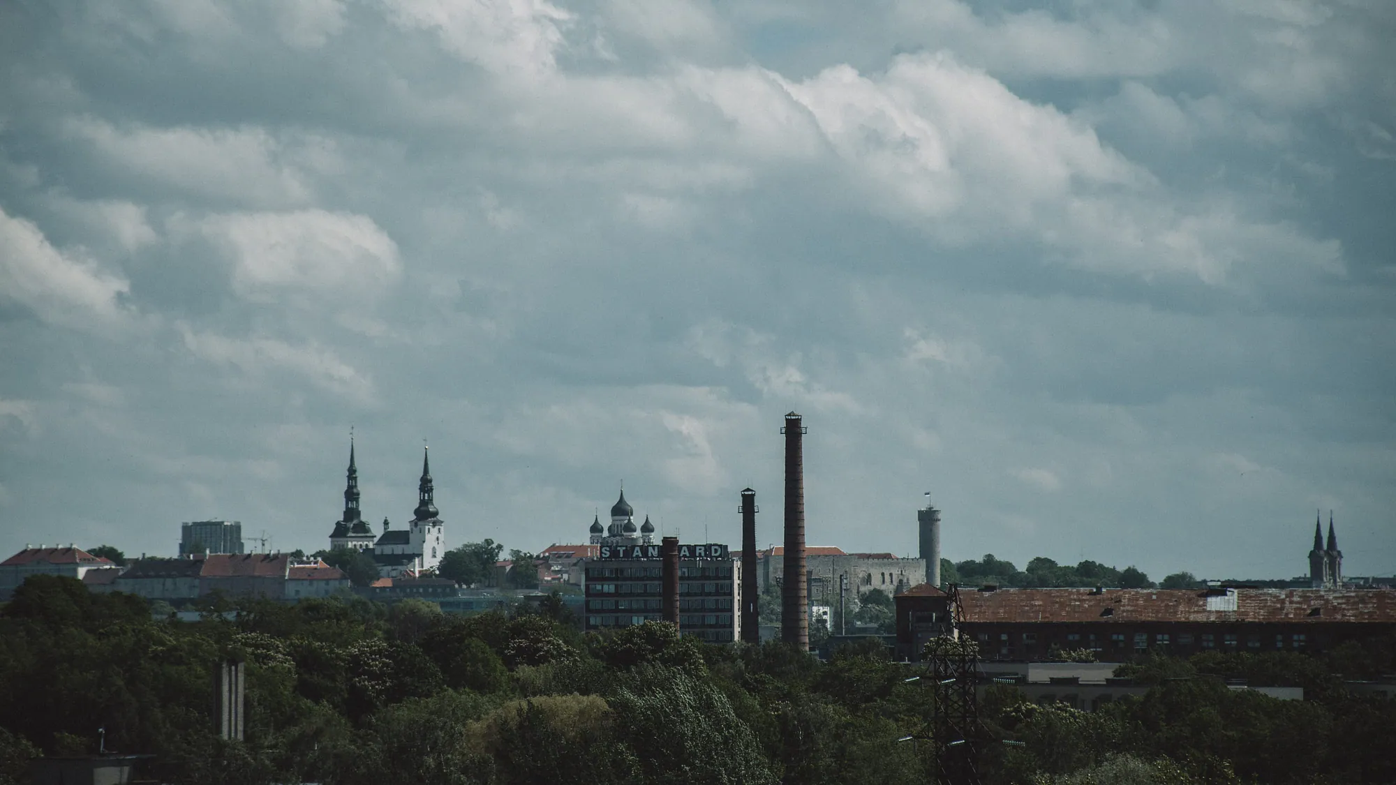 Tallinn skyline viewed across the roofs and industrial structures of Kopli