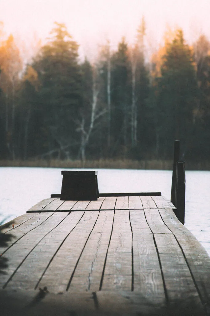 Rain-darkened wooden pier reaching into Järveotsa lake in autumn