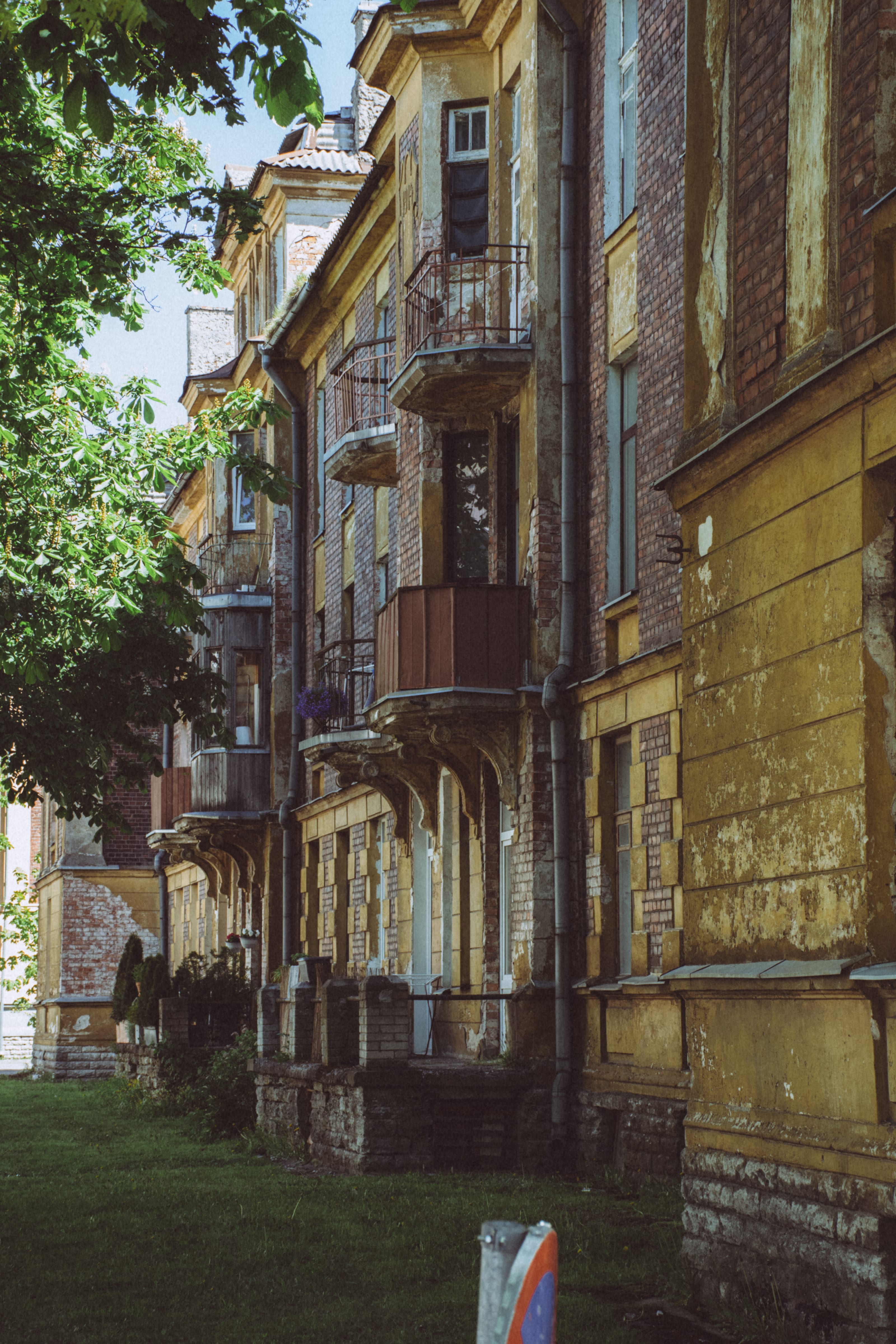 Sunlit historic apartment buildings lining a narrow Kalamaja street