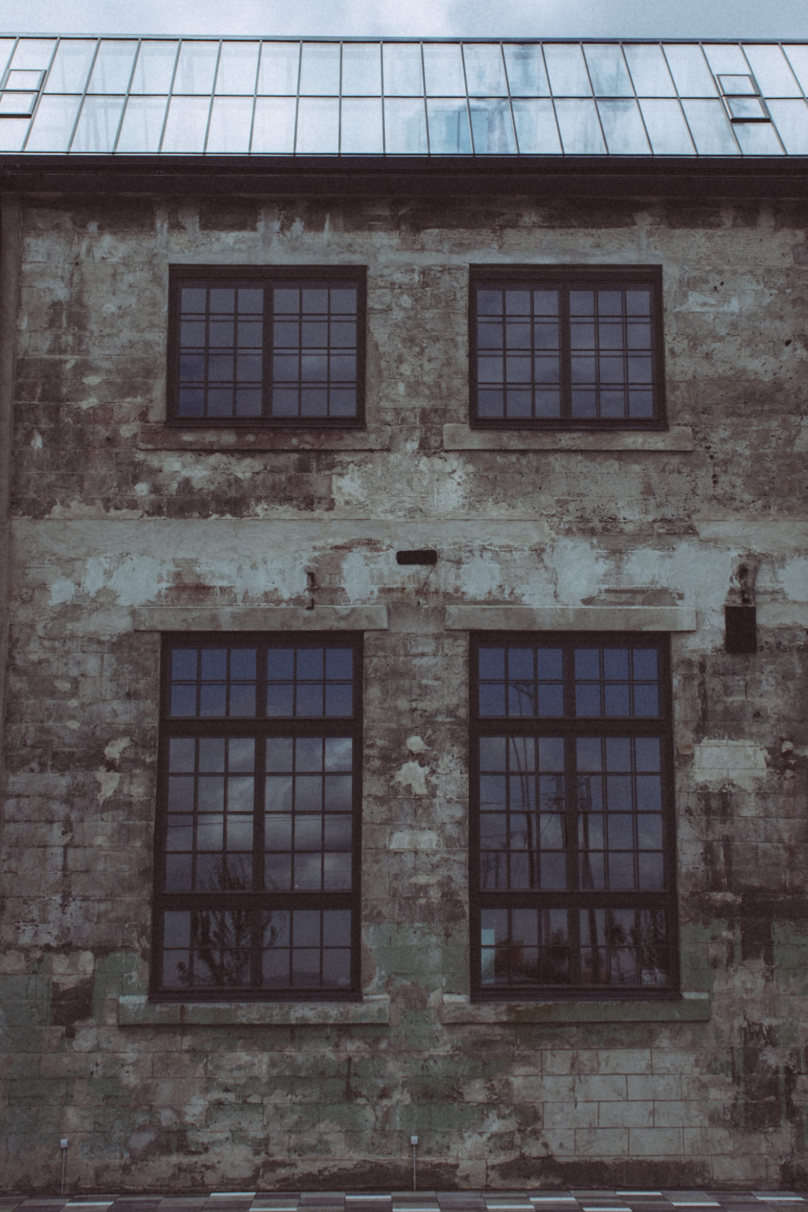 Faded industrial wall with gridded windows in Kopli, Tallinn, Estonia.