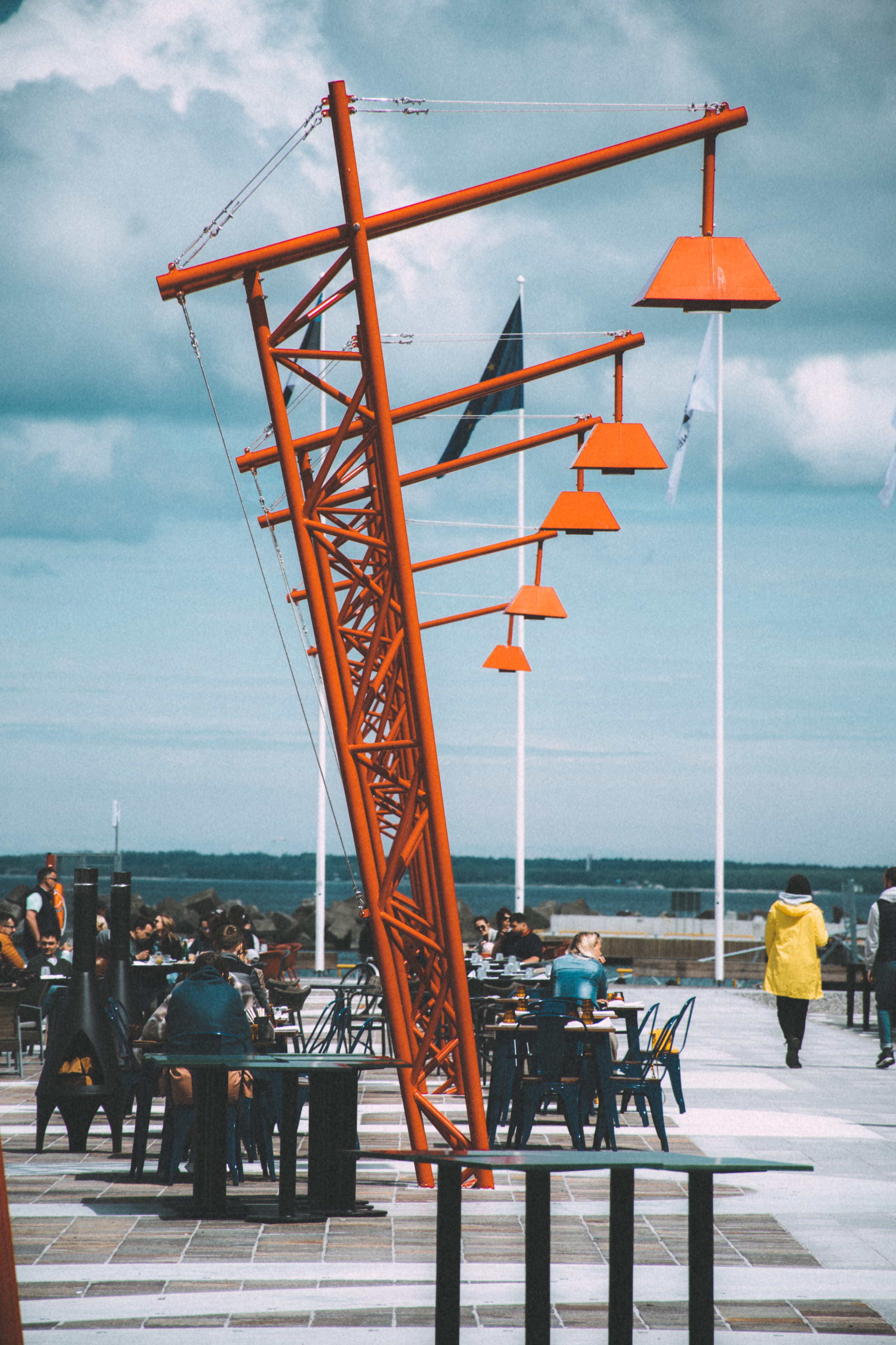 Red harbour crane and lamps on a seaside promenade in Kopli, Tallinn, Estonia.
