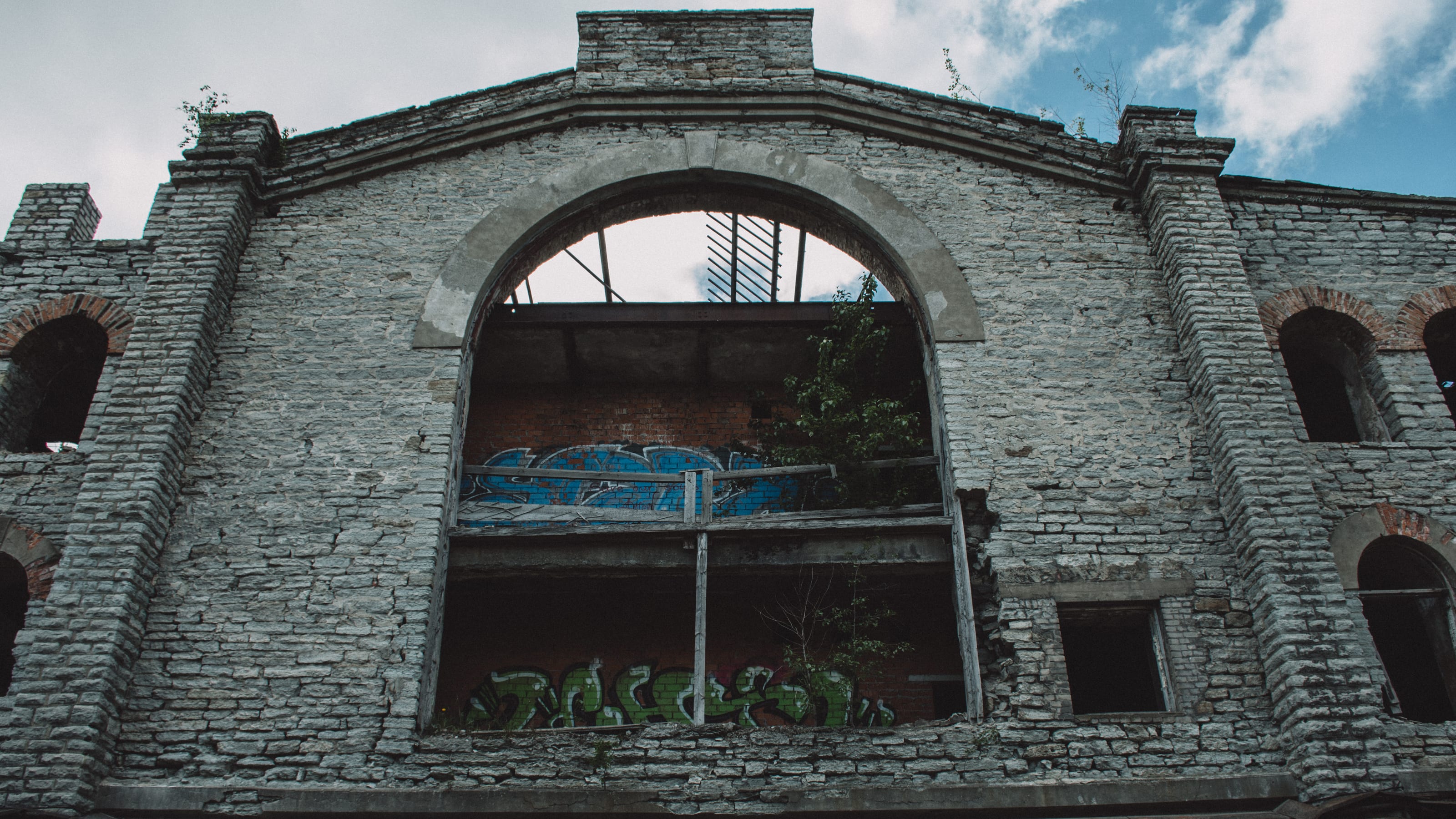 Ruined brick arch with an open upper window in Kopli, Tallinn, Estonia.