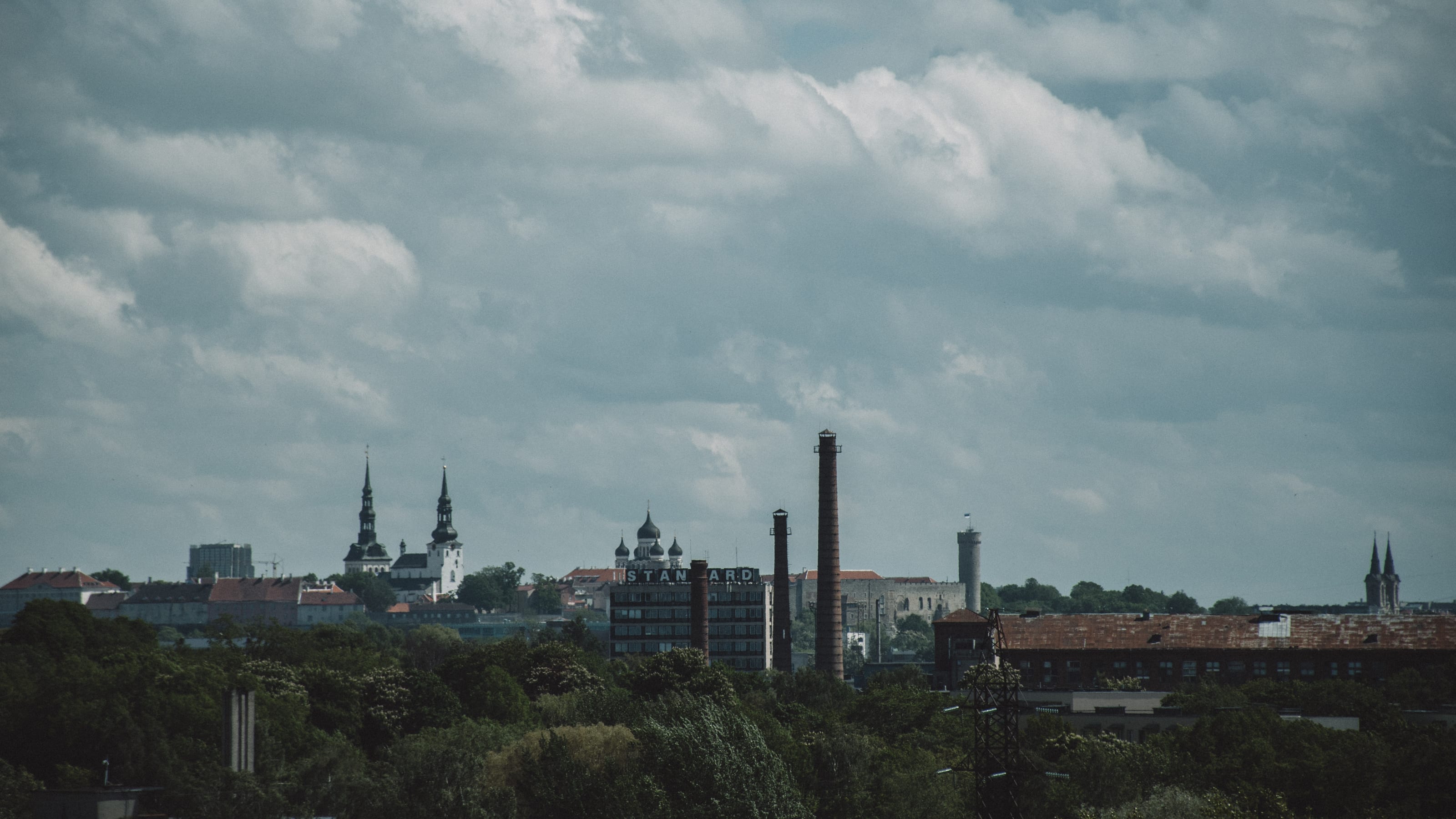 Old Town towers and industrial chimneys on the horizon in Kopli, Tallinn, Estonia.