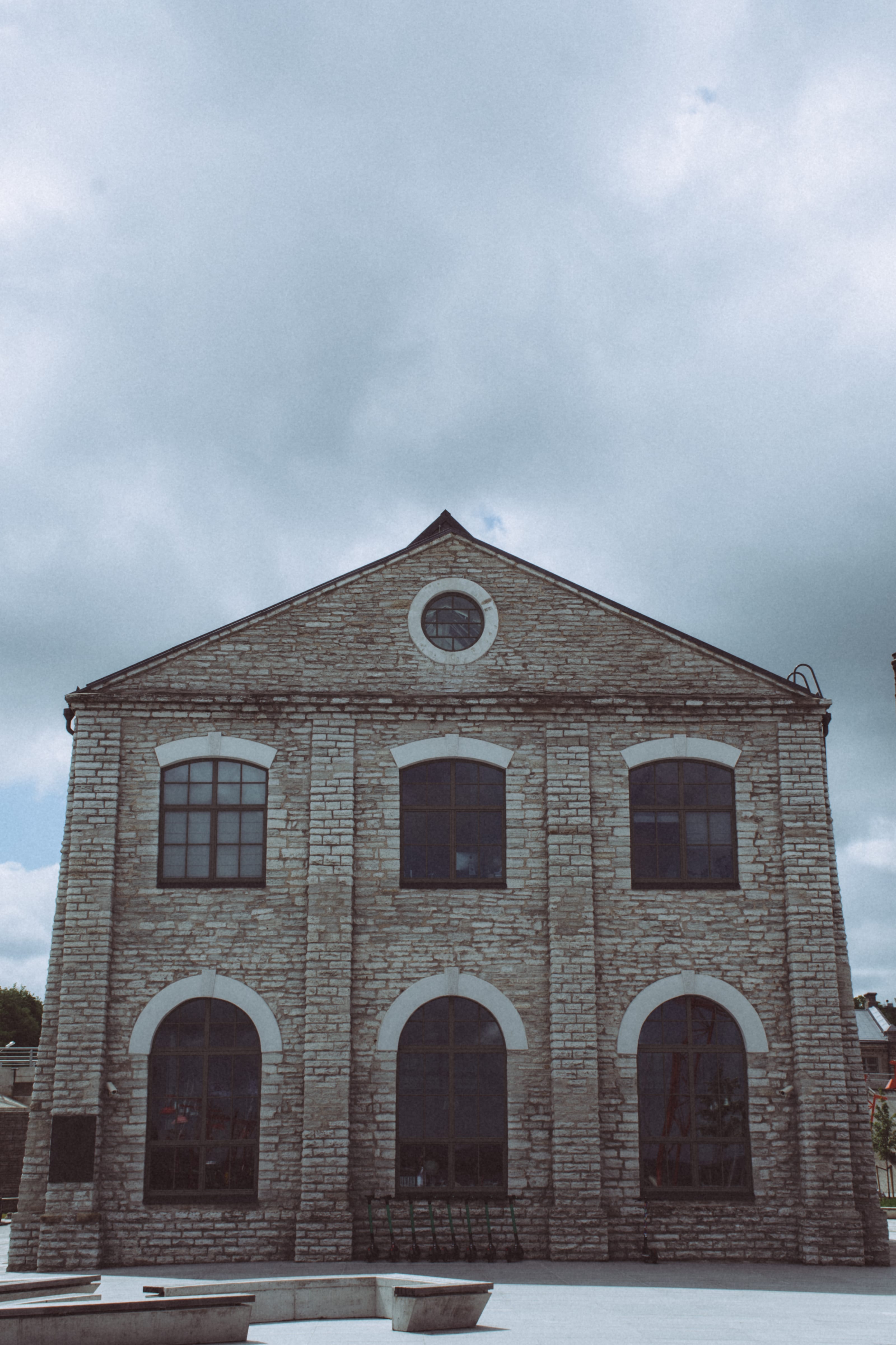 Symmetrical weathered industrial facade beneath a cloudy sky in Kopli