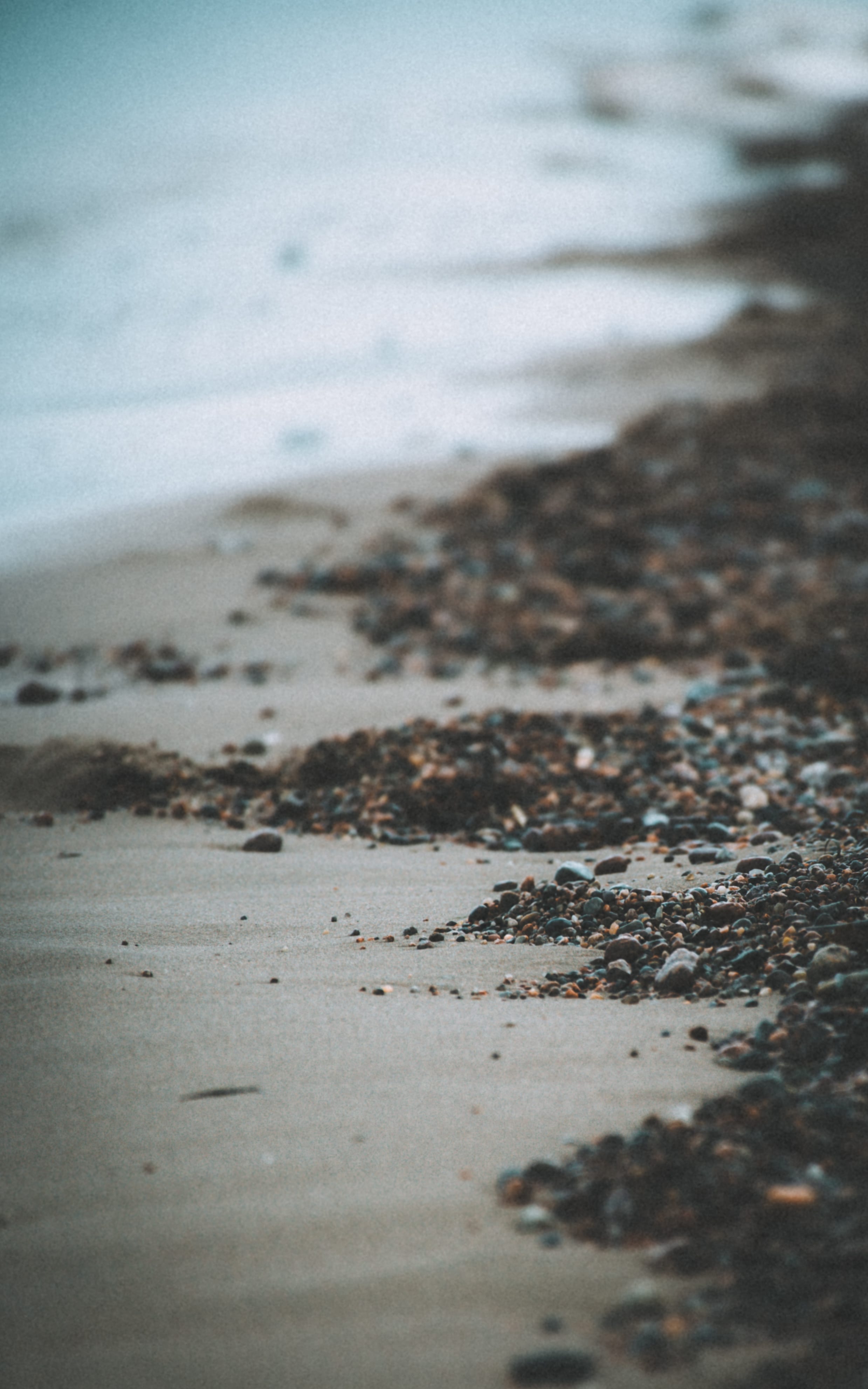 Foam and dark sand along a quiet Baltic shoreline in Neeme, Estonia.