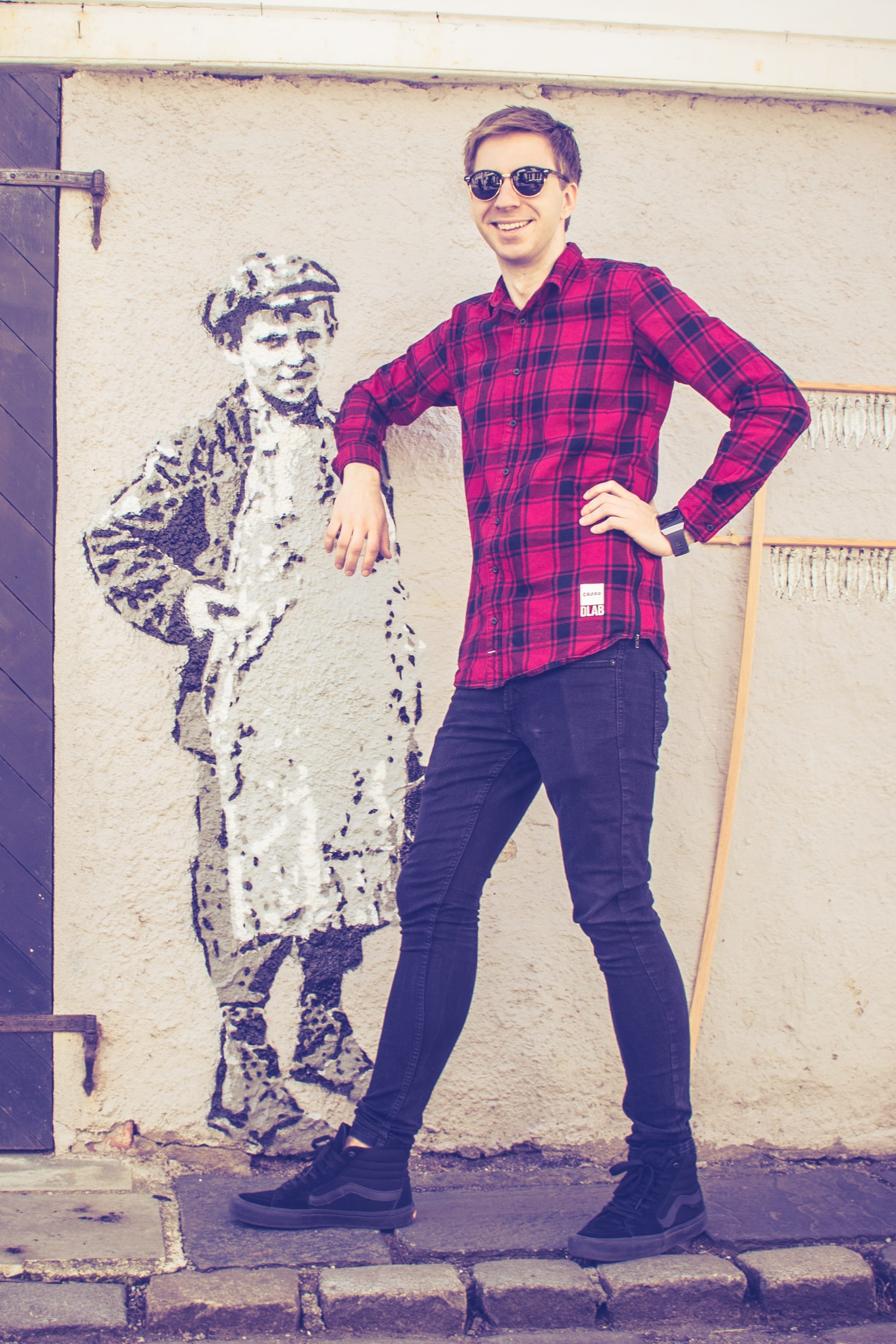 Traveller posing beside painted street art in coastal Norway.