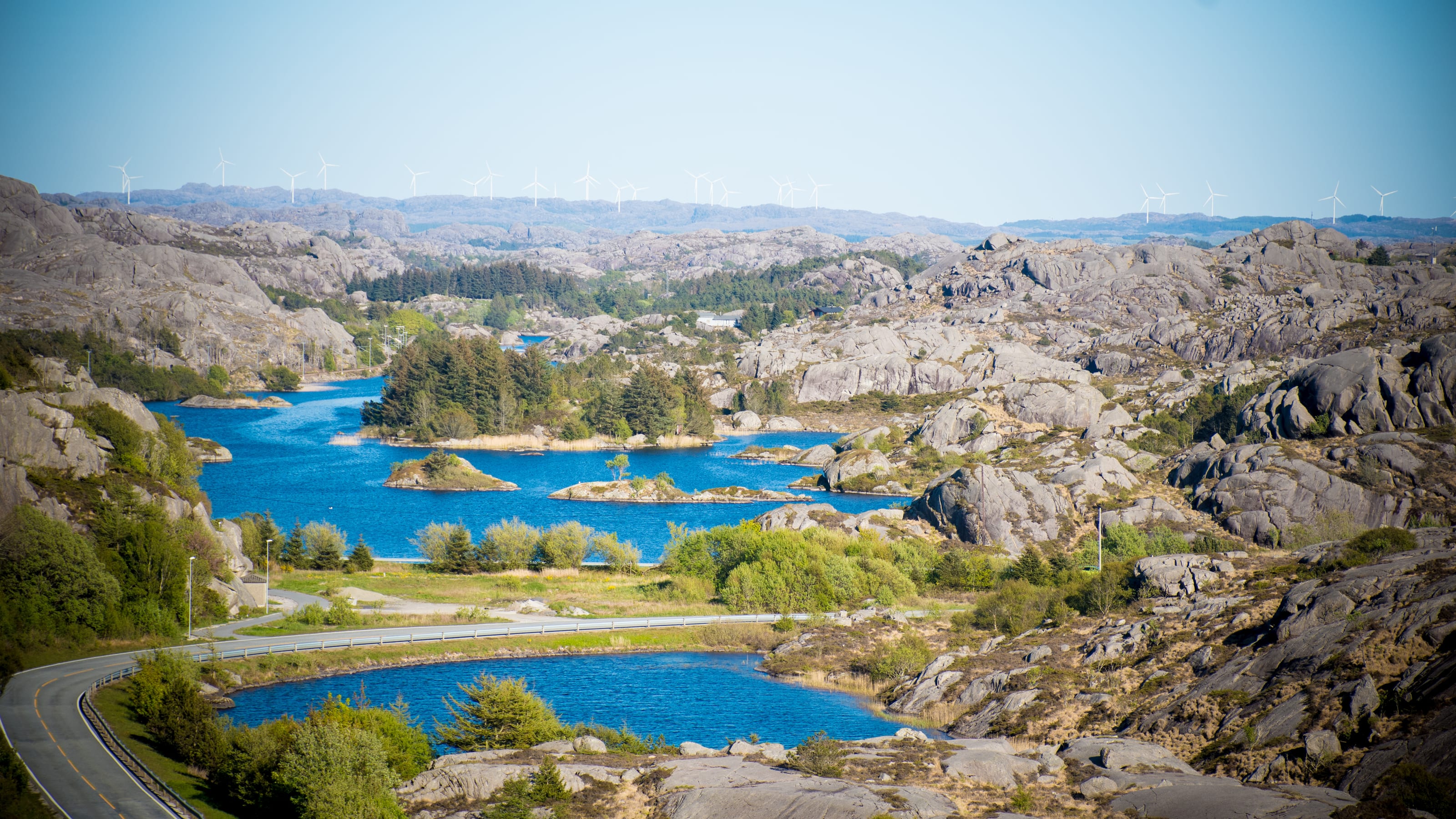Blue lakes winding between pale granite hills in coastal Norway.
