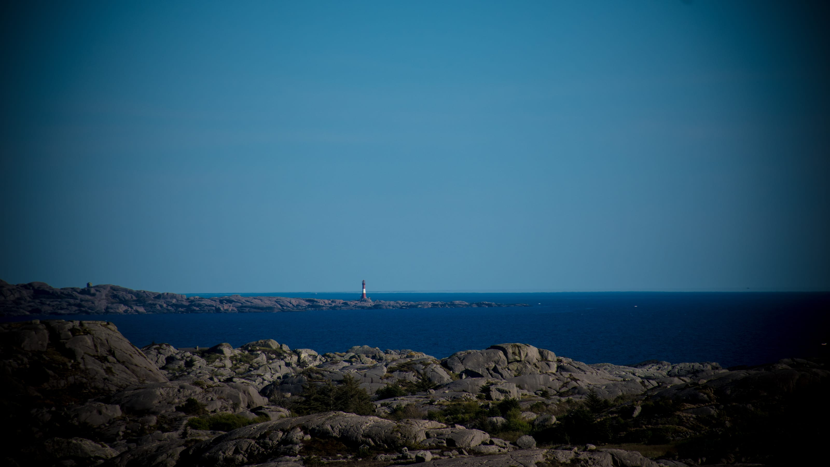 Rocky shoreline meeting a deep blue sea in coastal Norway.
