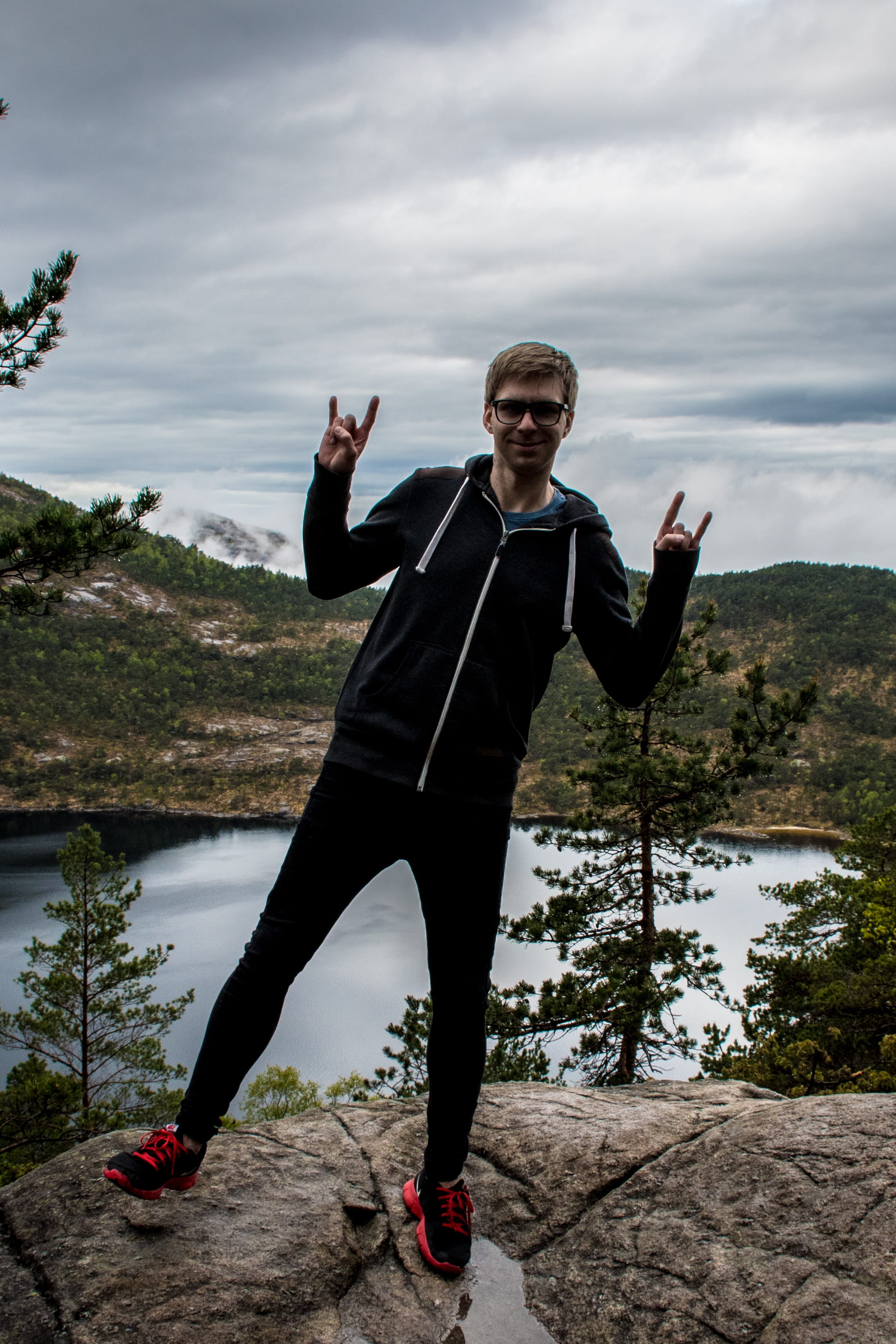 Traveller celebrating beside a highland lake in coastal Norway.
