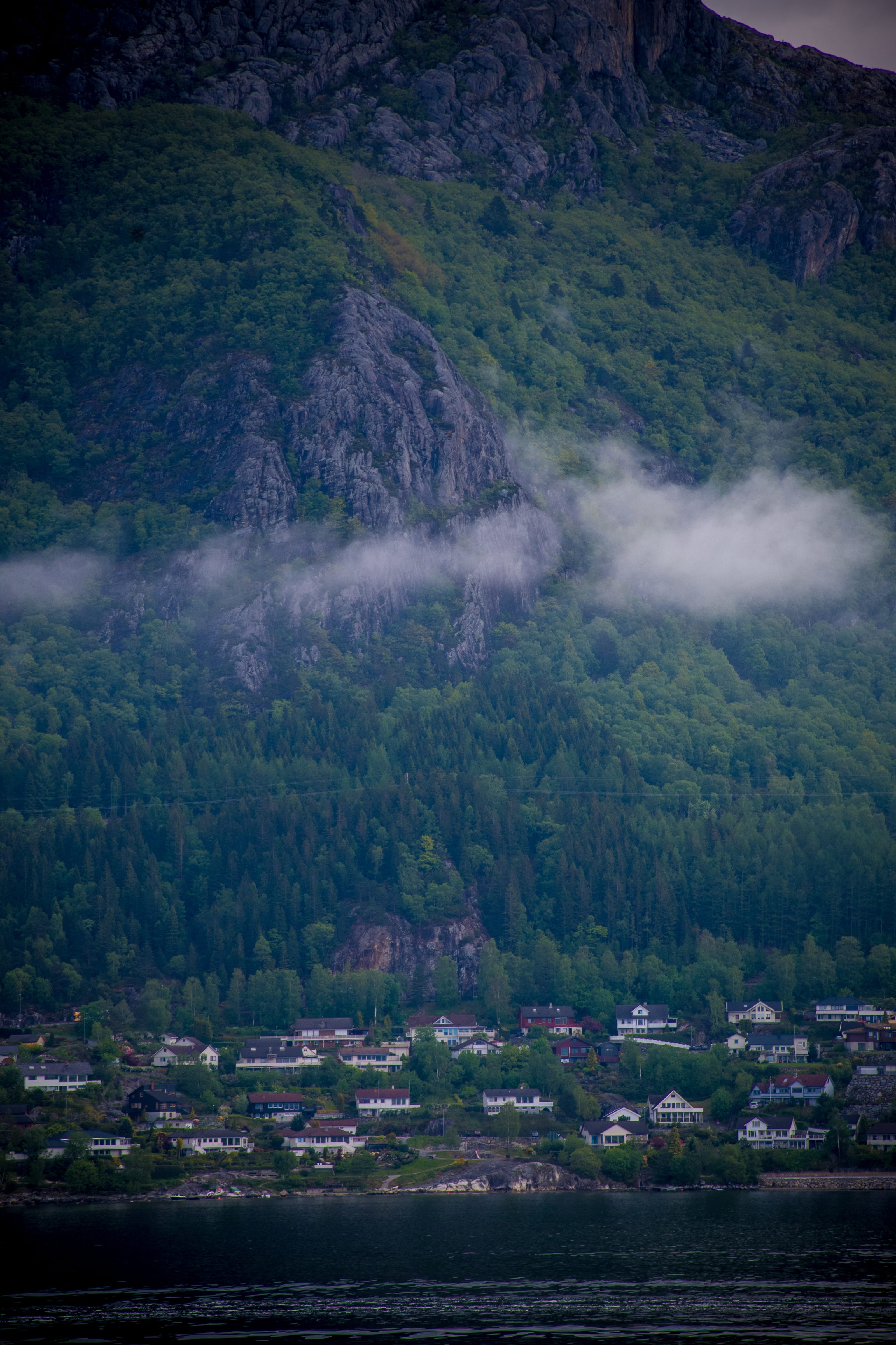 Village pressed between a steep mountain and the fjord in coastal Norway.