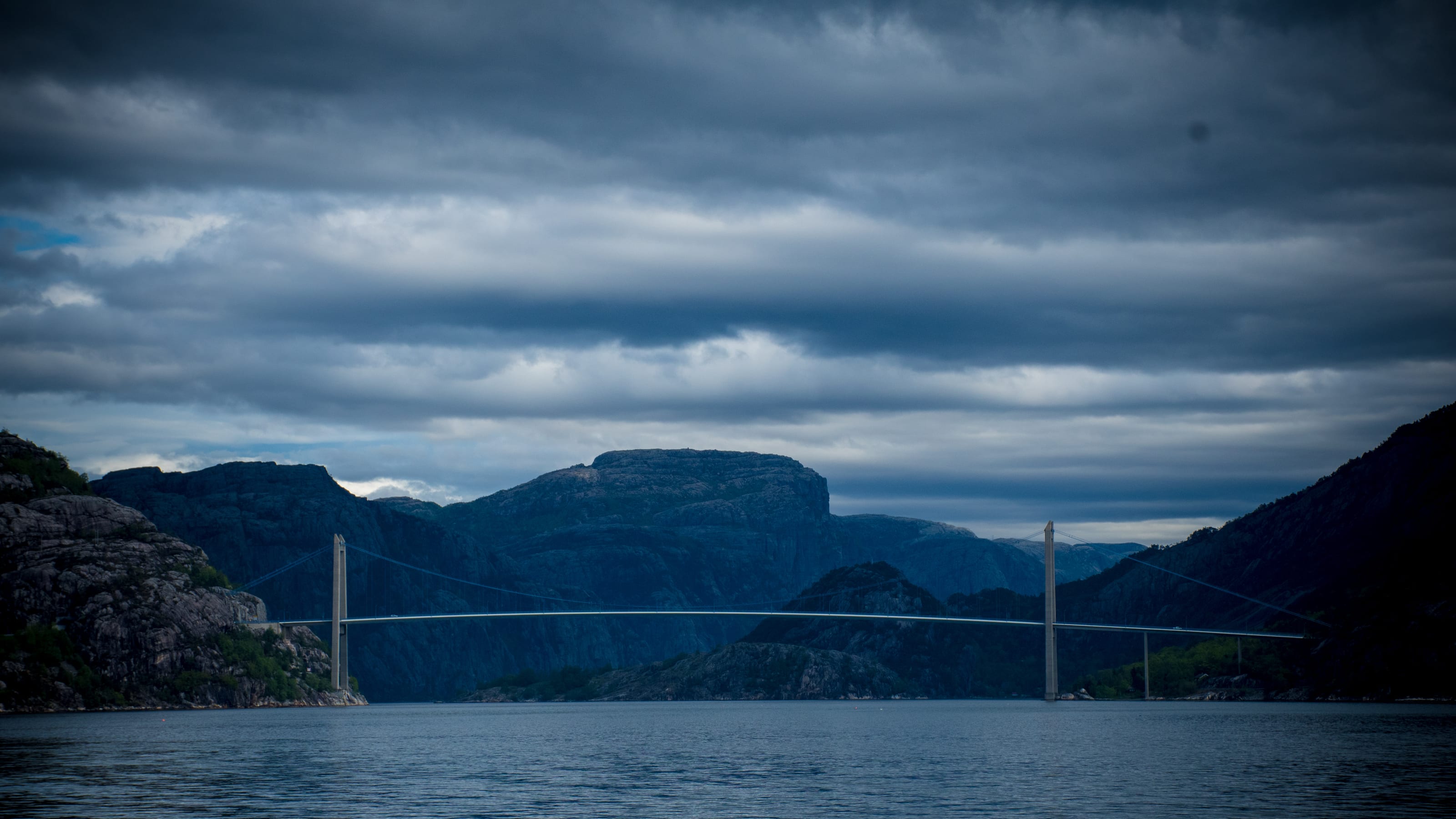Mountain descending into cloud above a waterside village in coastal Norway.