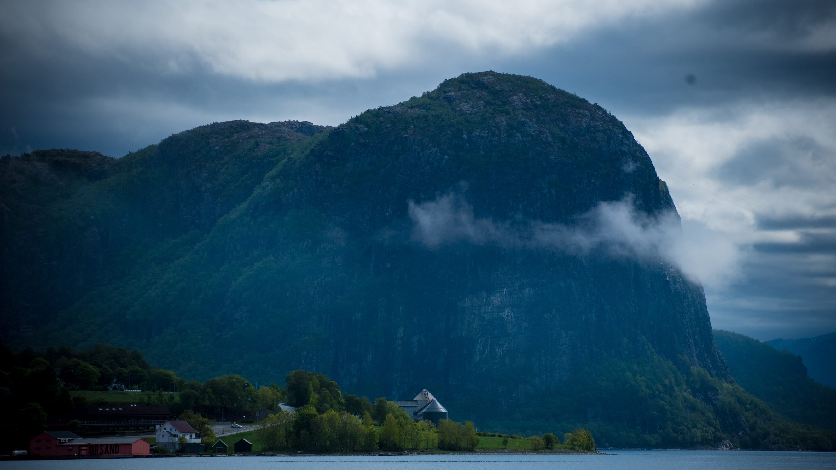 Wind-driven waves crossing a blue coastal inlet in coastal Norway.