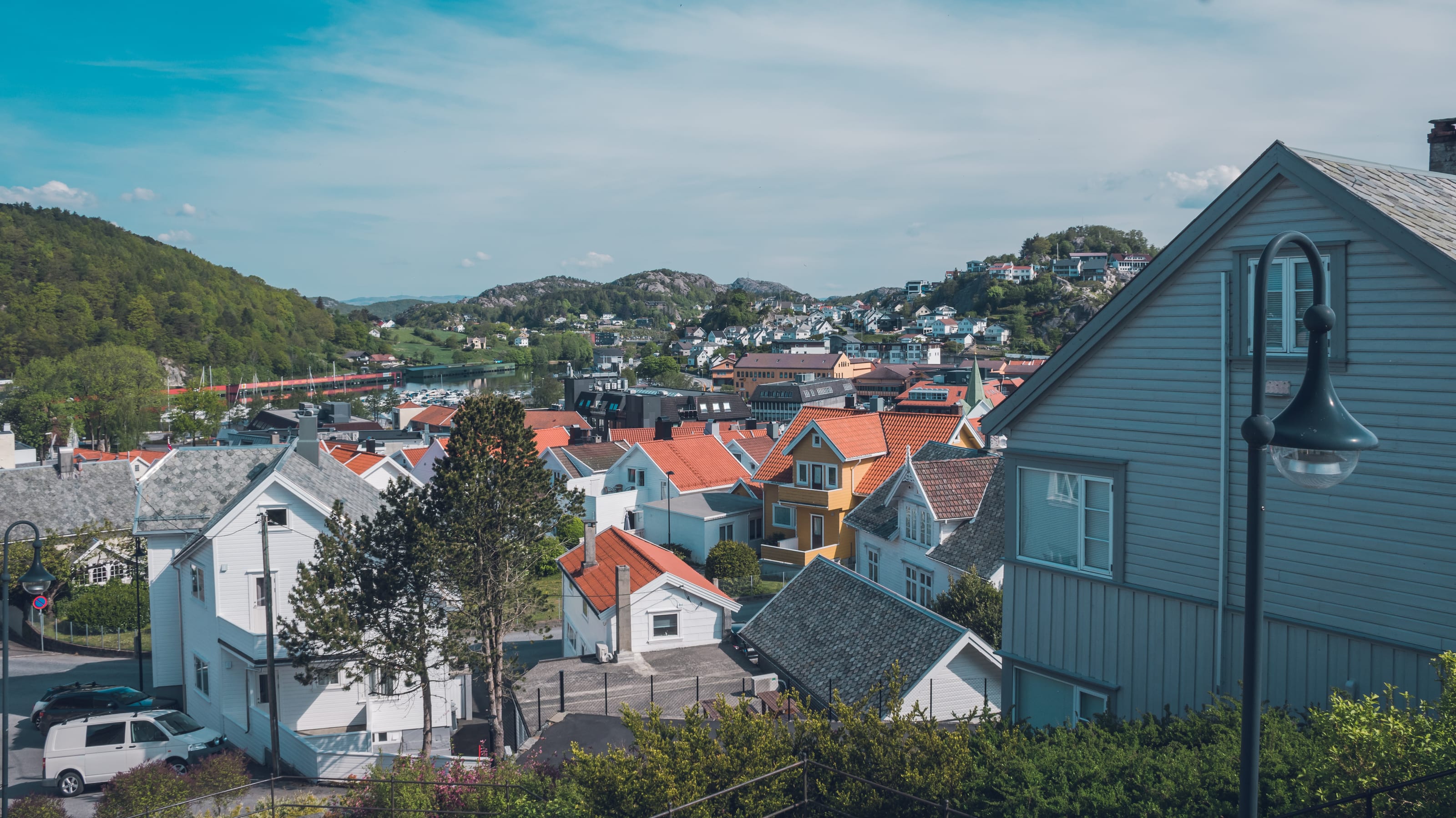 White houses scattered across a rocky coastal slope in coastal Norway.