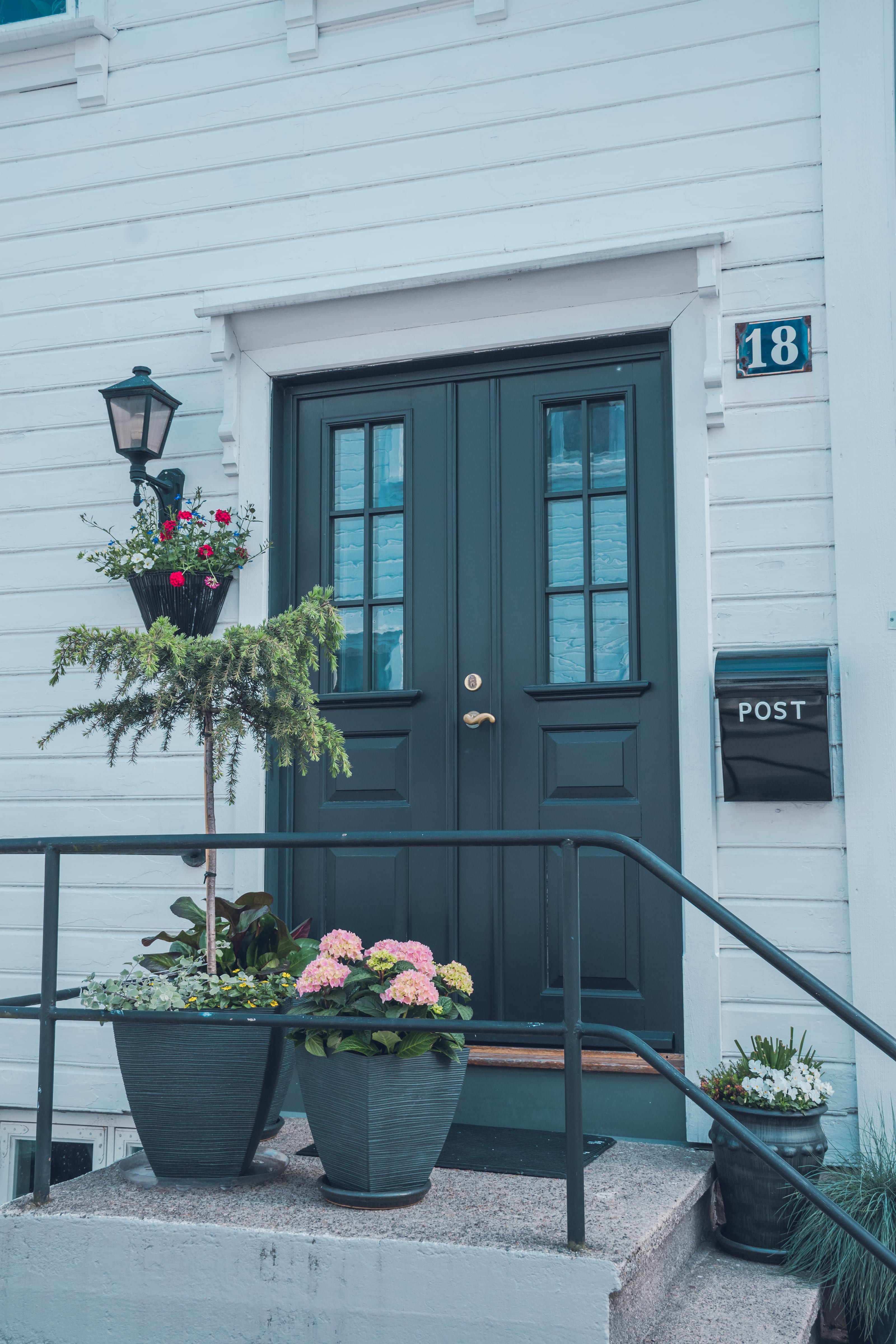 White wooden house standing on a quiet street corner in coastal Norway.