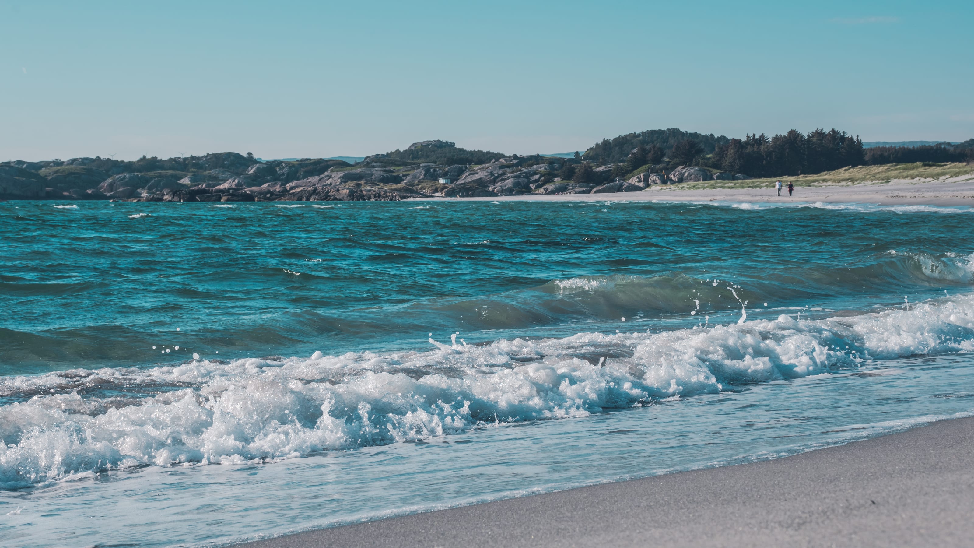 Curving beach between granite headlands in coastal Norway.