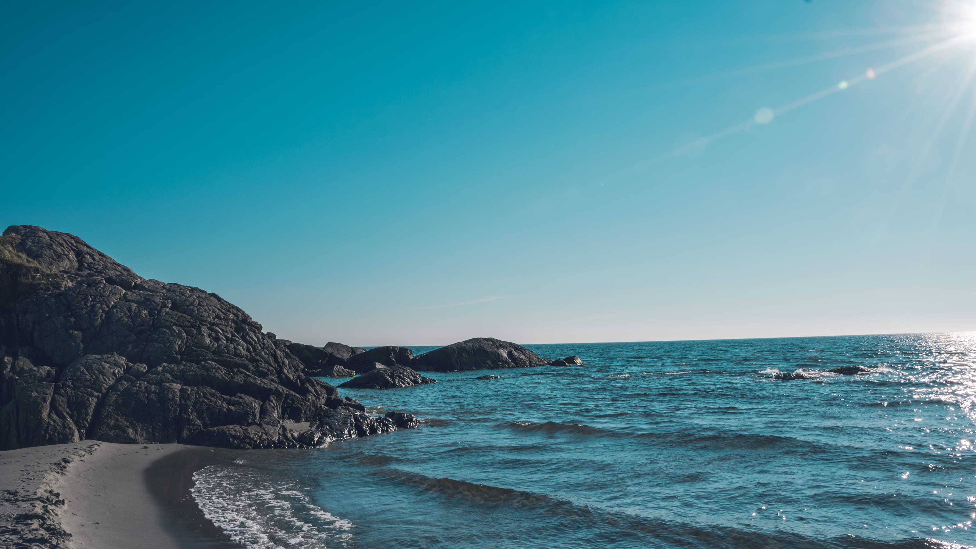 Low rocky island beneath a clear turquoise sky in coastal Norway.