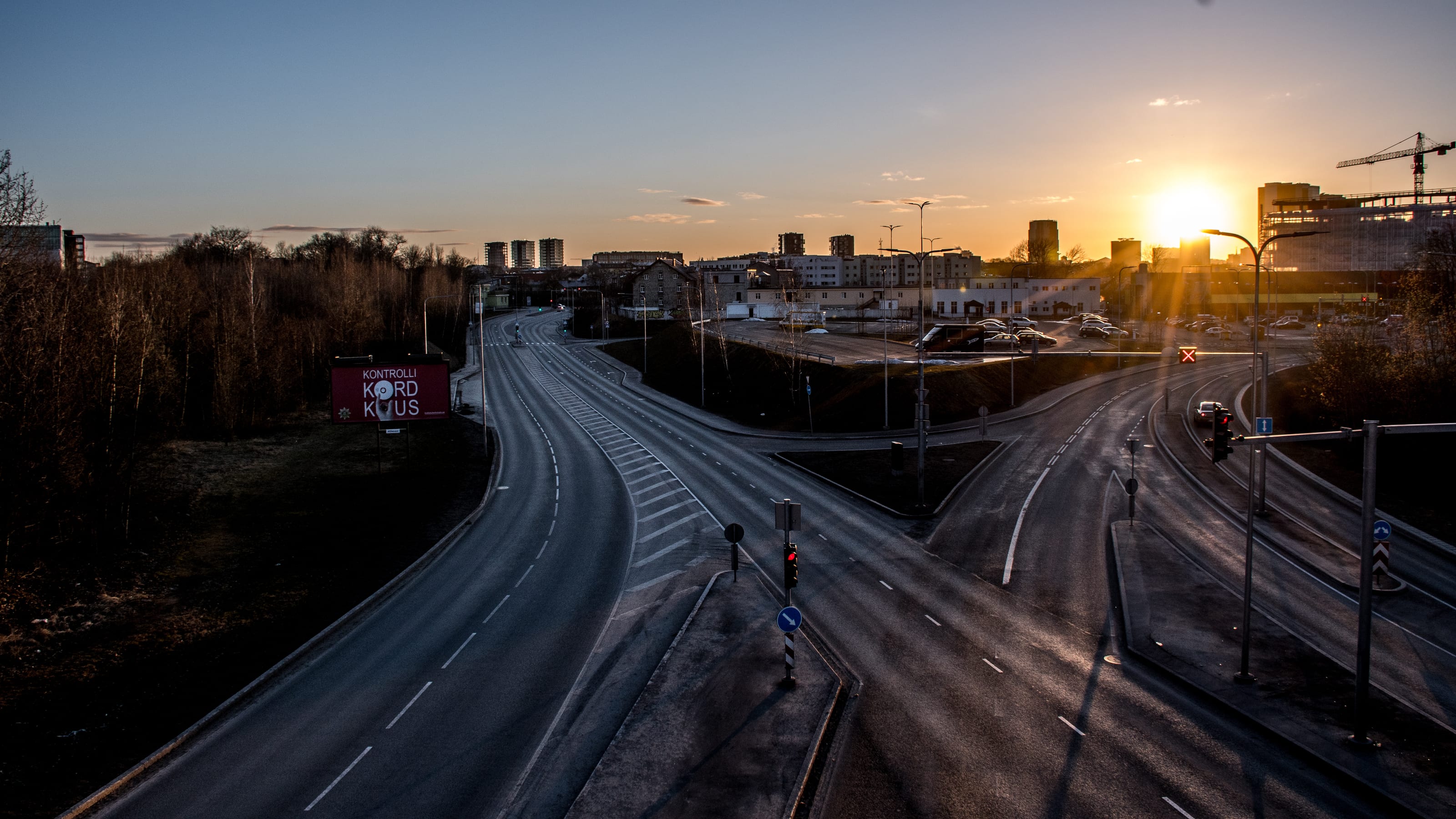 Empty Tallinn road junction leading toward a low golden sunset