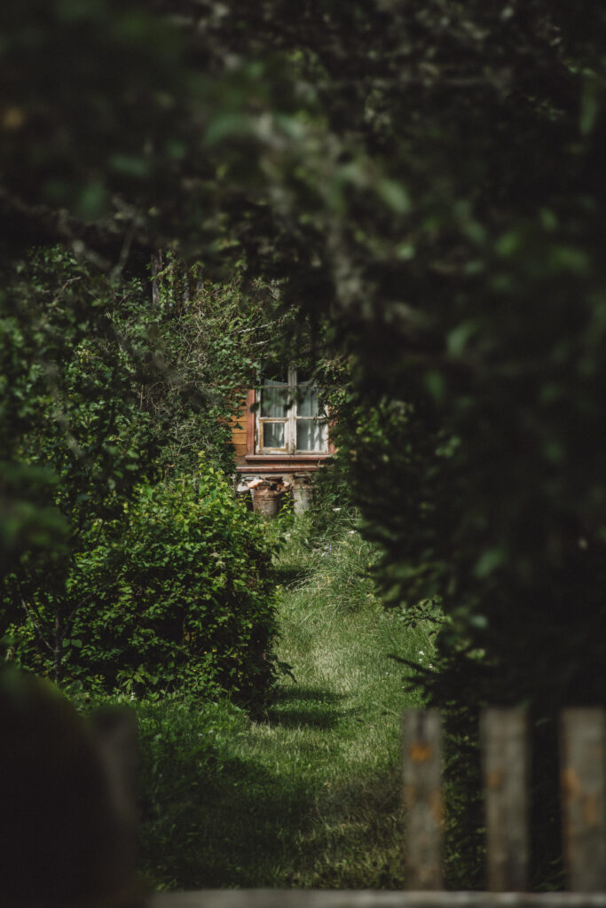 Grassy foreground with a traditional Estonian house in the background in Aegviidu